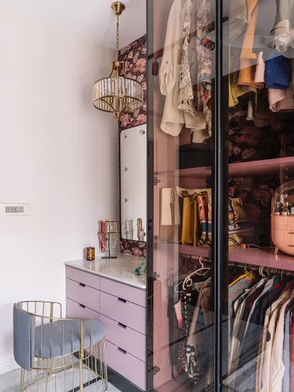 The 'before' stage of a walk-in closet, showing the initial setup of the lilac-colored drawers and vanity area before the final lighting and mirror were installed.