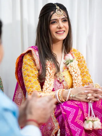 All set for her poojan ceremony. This look is simple and minimal, with a focus on dewy skin and soft features to complement her traditional Bandhani saree.