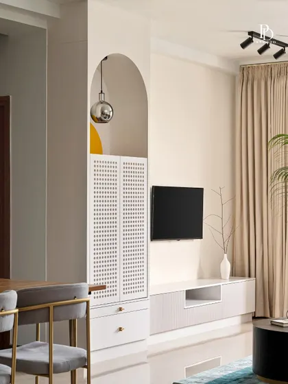 A closer look at the custom bar and TV unit, showcasing the use of an arched niche and perforated cabinet doors. These details add a layer of texture and sophistication to the living area.
