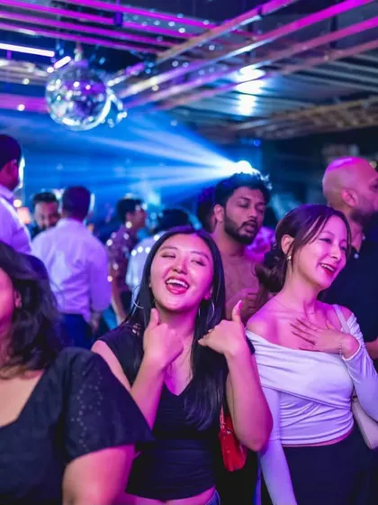 Friends laughing and singing along on the dance floor at Gawky Goose.