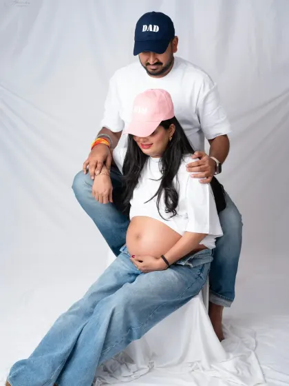 Having fun with props. The "Mom" and "Dad" hats add a playful and personal touch to this casual couple's shoot in jeans and white tees.