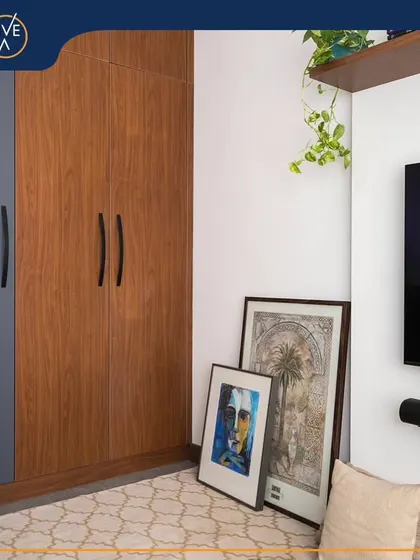 A different angle of the cozy corner, showing how curated art pieces leaning against the wall can add a personal and artistic touch. The design integrates storage, work, and display space seamlessly.