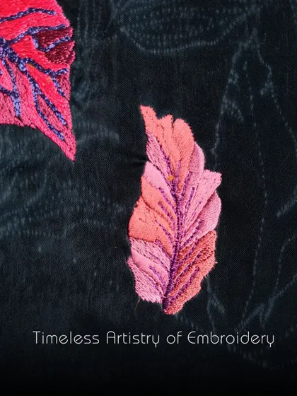 Timeless artistry of embroidery. A close-up of a vibrant pink leaf, intricately stitched onto black fabric, showcasing the beauty that resonates in every stitch.