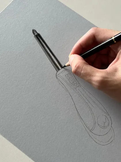 The initial stages of a realistic screwdriver drawing. I start with a precise outline and then begin blocking in the darkest areas of the handle to establish the form.