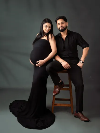 A stylish and modern couple's portrait. The coordinated all-black outfits and classic studio posing give this shot a sophisticated, magazine-like feel.