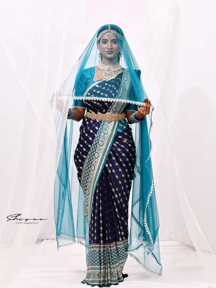 This image showcases a creative use of a sheer veil, adding a layer of mystique and elegance to the traditional South Indian bridal look.