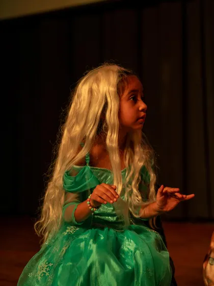 An actress in a beautiful green dress and wig, fully embodying her fairytale character. Costumes are a fun part of the process that helps spark imagination.