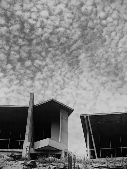 The bold, angular forms of the resort cottages stand against a dramatic sky, showcasing the power of the design even during construction.