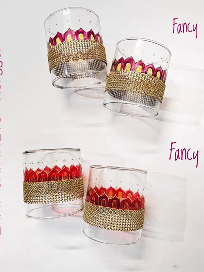 The 'Fancy Rose' and 'Fancy Red' lamp chimneys, featuring warm pink and red tones complemented by a sparkling gold beaded lace.