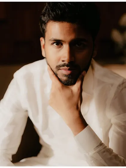 A classic portrait of a handsome South Indian groom in a crisp white shirt.