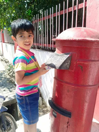 Another young student experiences the joy of mailing a letter, a memorable moment from our educational trip to the post office.