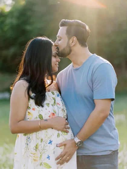 There's something magical about a sunset session. Here, the golden light wraps around this beautiful couple, highlighting the tender kiss and the promise of their growing family. Outdoor maternity photography in a natural setting like this feels so timeless.