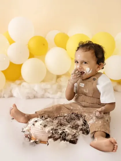 Enjoying every last bite! This little one is making the most of his first birthday cake.