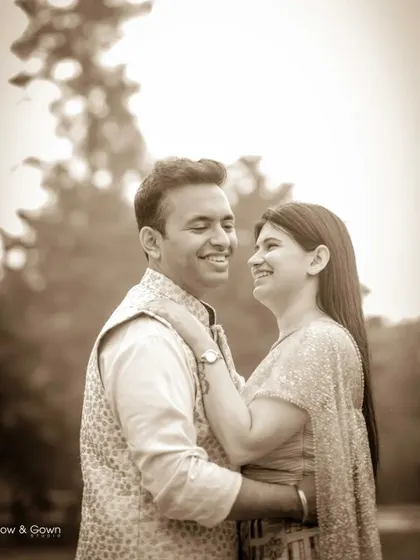 A sepia-toned pre-wedding portrait that gives the photo a warm, vintage feel. The couple's happy smiles and close embrace make this a timeless and romantic image.