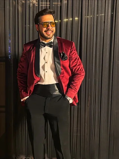 A classic, confident stance in a red velvet tuxedo, looking sharp and ready for a grand evening.