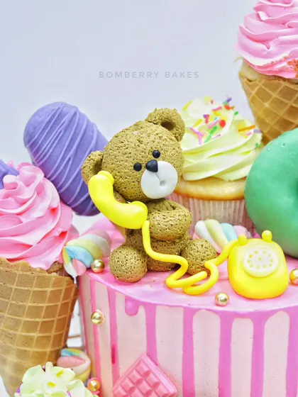 This candy-overloaded cake is a feast for the eyes, topped with a sweet fondant teddy bear chatting on a retro telephone. My workshops cover creating these charming, textured figurines.