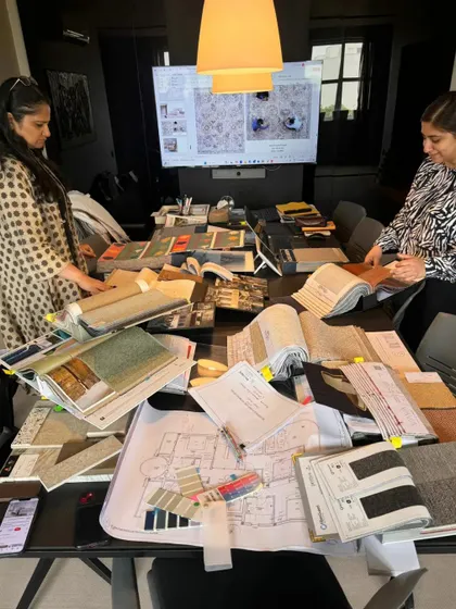 A shot of our design team deep in the material selection process, with a table full of fabric books, samples, and plans.