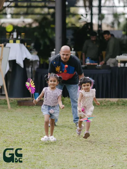 A father chasing his daughters on the lawn. We are a place for creating happy family memories.
