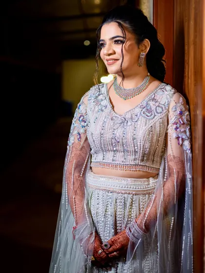 A serene portrait of the bride, showcasing her elegant updo and the intricate beadwork on her blouse.