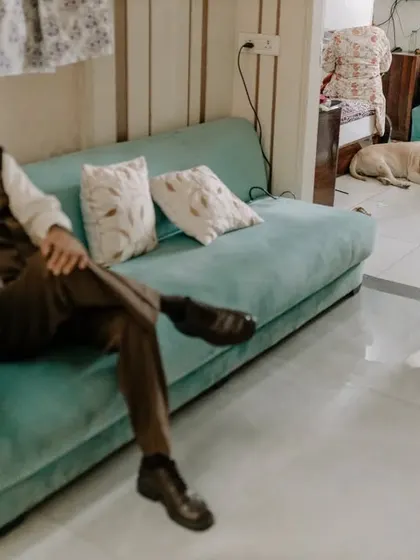 Even the family pet is part of the wedding story. A relaxed, candid moment of the groom on his phone while his dog rests nearby.