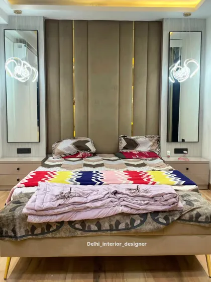 A straight-on view of the bed and the stunning accent wall. The vertical panels of the headboard make the ceiling feel higher.