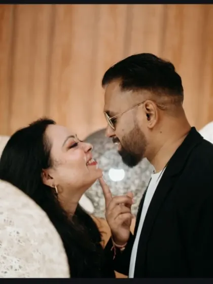 A sweet and candid moment captured during a pre-wedding session. The bride-to-be gently touches her partner's chin, creating a photo filled with affection.