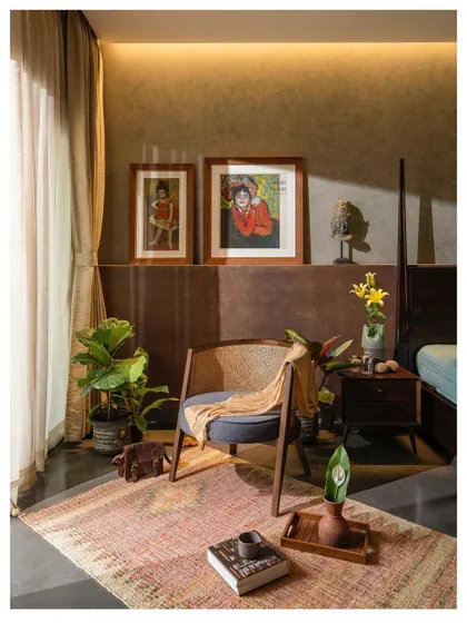 A cozy reading corner in a bedroom, featuring a classic mid-century modern chair. We create these small, personal nooks within larger spaces for moments of quiet reflection.