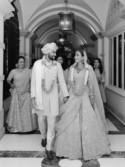 Manvi and Aakash walking hand-in-hand after their ceremony. This black and white candid shot captures the joy and relief of the moment perfectly.