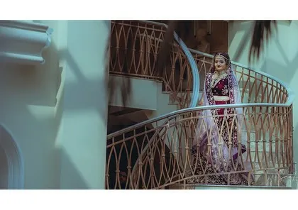Using the architecture of a spiral staircase to frame the bride. This creates a dramatic and visually interesting portrait that showcases her full bridal attire.