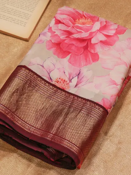 A beautiful floral printed Kanjivaram in shades of pink on a cream base, paired with a rich maroon border.
