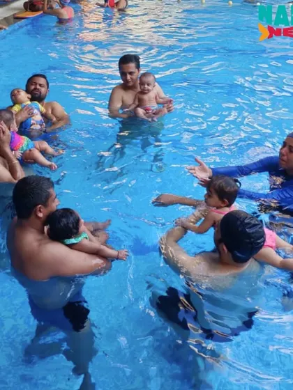 A snapshot of a group class where dads and babies learn together in a circle.