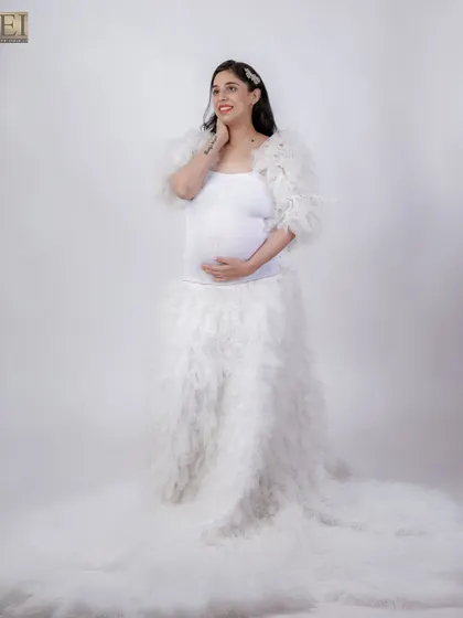 An angelic look with a white feathered gown against a clean white studio background.