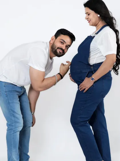 The father-to-be playfully listens to the baby bump. These fun and interactive poses are a great way to capture the excitement of waiting for your little one.