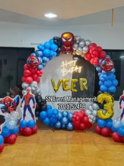 A super-heroic Spider-Man theme for Veer's 3rd birthday. The balloon arch in red, blue, and silver is complemented by multiple Spider-Man cutouts and a neon sign.
