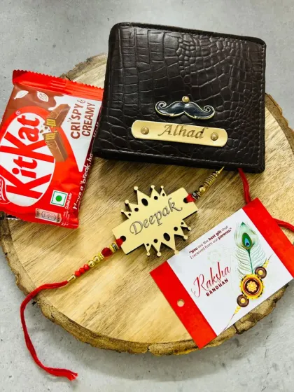A Rakhi combo featuring a personalized wallet and a matching crown-themed name rakhi, presented on a rustic wooden slice with a KitKat.
