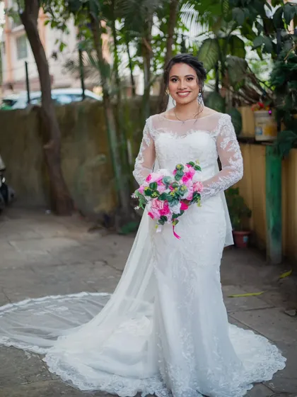 A full-length shot of the bride looking absolutely radiant. Her subtle, glowy makeup and elegant updo are the perfect complement to her detailed lace gown.