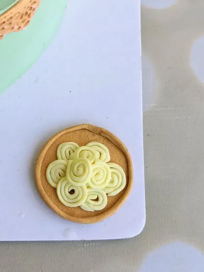 A mini fondant plate of murukku (chakli), handcrafted for a traditional baby shower cake. These tiny edible details help to create a rich, thematic story.