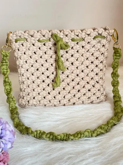 A beautiful example of my custom work, this sling bag combines a natural cream body with a vibrant green drawstring and a matching twisted strap.