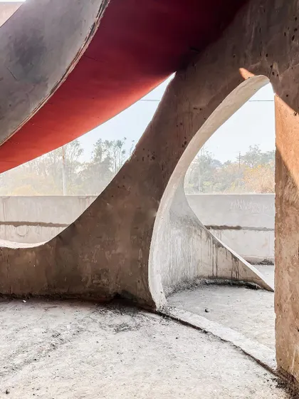 Sunlight streams through the curved openings of the "La La Land" structure, creating a beautiful play of light and shadow on the unfinished surfaces.
