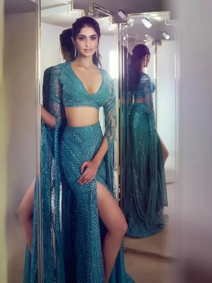 A fully sequined teal lehenga with a dramatic cape sleeve is a guaranteed head-turner. Let's work together to create your own version of this showstopping look.