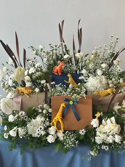 A sophisticated take on the jungle theme, this hamper combines wild animal figures with an elegant arrangement of white flowers and greenery.