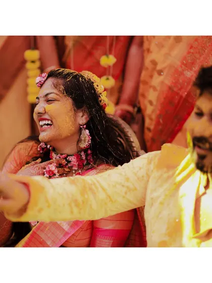 A candid moment of laughter between the bride and groom during their Haldi ceremony. These unscripted interactions are what make the memories so precious.