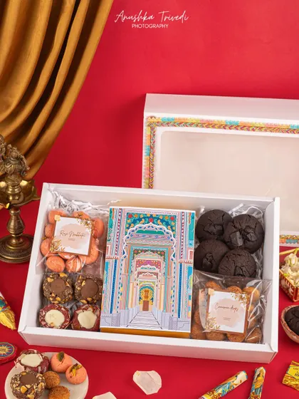 A large white Diwali hamper box filled with cookies and sweets, featuring colorful, Jaipur-inspired packaging details.