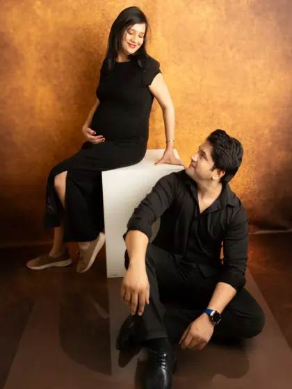 A modern and stylish couple's portrait. The use of a simple white block and a textured backdrop adds a contemporary feel to the session.