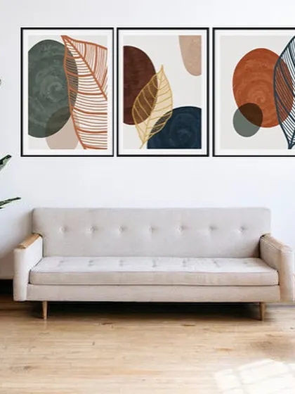 A set of three framed prints that combines abstract shapes with delicate leaf line art. The earthy tones and varied compositions create a beautiful and cohesive triptych that brings a touch of nature indoors.