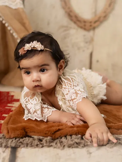 Tummy time! This pose is great for showing off a 5-month-old's strength and curiosity, and she looks so sweet in her lacy outfit.