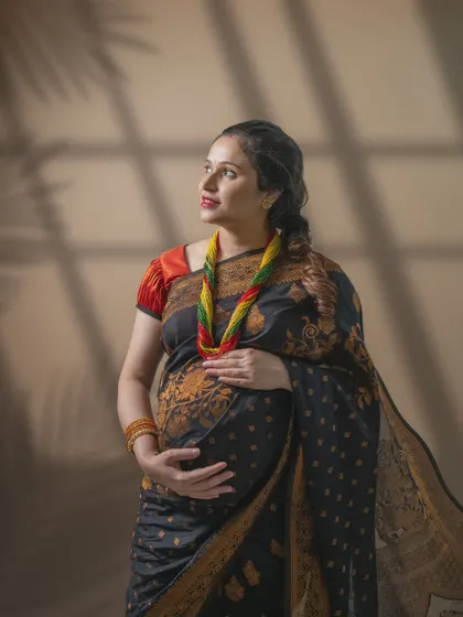 Grace in tradition. The soft play of light, the intricate details of the black and gold saree, and her radiant glow all speak of timeless beauty.