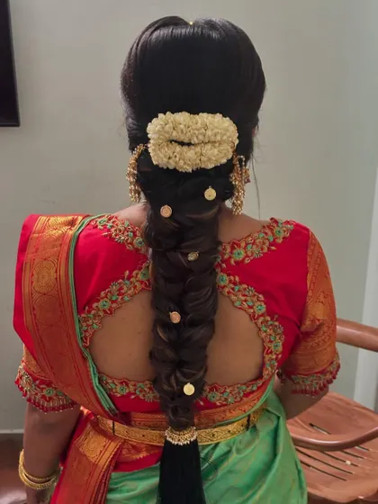 A thick fishtail braid decorated with a jasmine gajra and small gold pins. This style adds volume and texture.