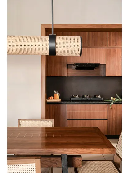 When working with small spaces, restraint with materials is key. In the 'Kayu' dining area, the continuity of wood from the kitchen creates a cohesive language, making the space feel larger and more unified.