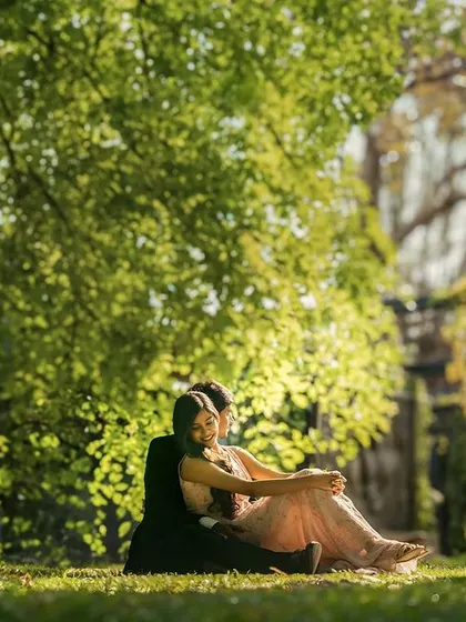 A peaceful moment shared under the shade of a large tree. This image captures a feeling of quiet intimacy and comfort, away from the hustle of the world.